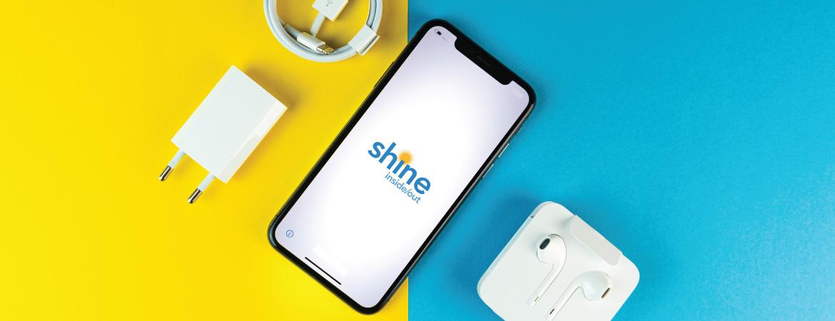 Photo of an iPhone with the Shine logo on the screen