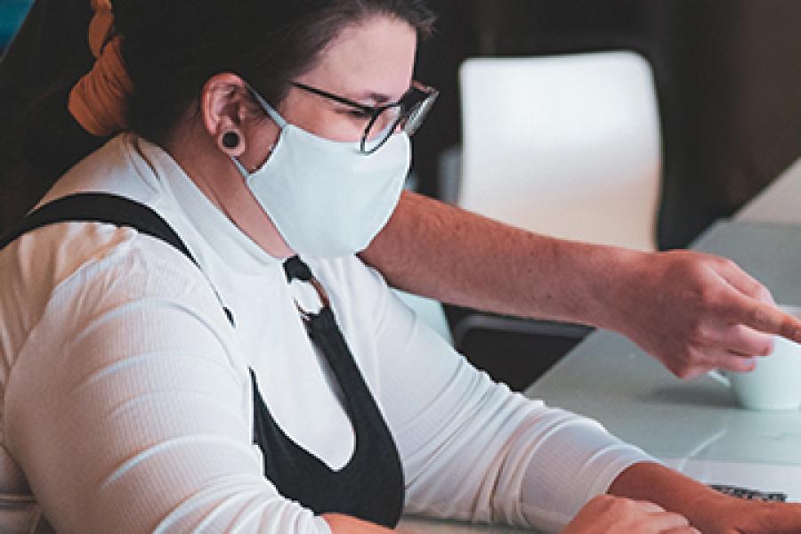 Woman at computer with glasses and face mask
