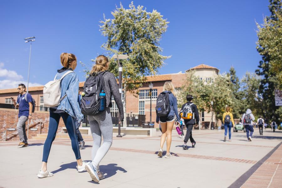 Candid photo of students walking on campus in Bruin Plaza