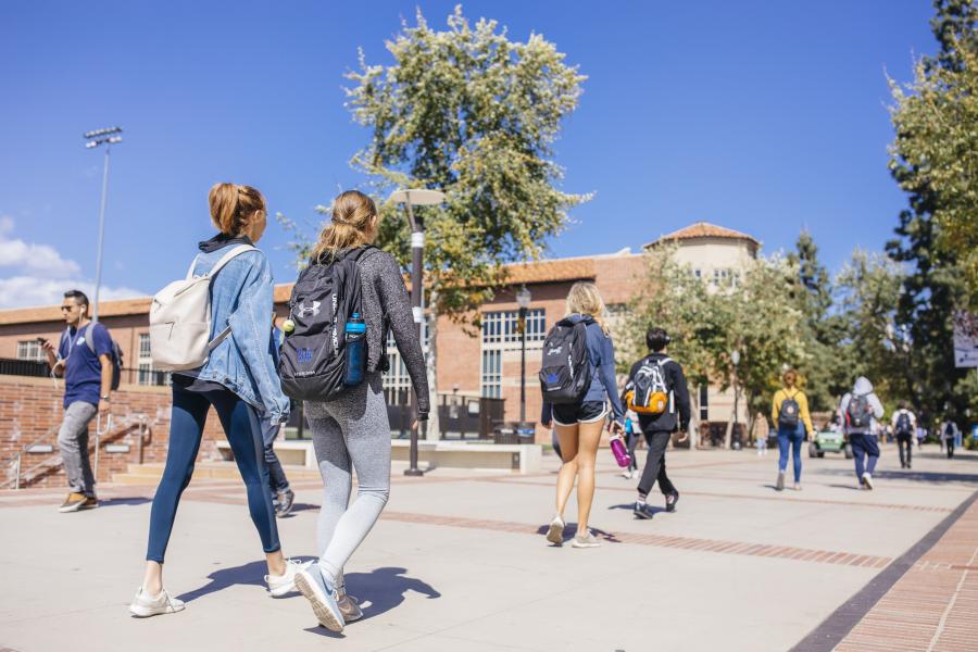 Candid photo of students walking on campus in Bruin Plaza