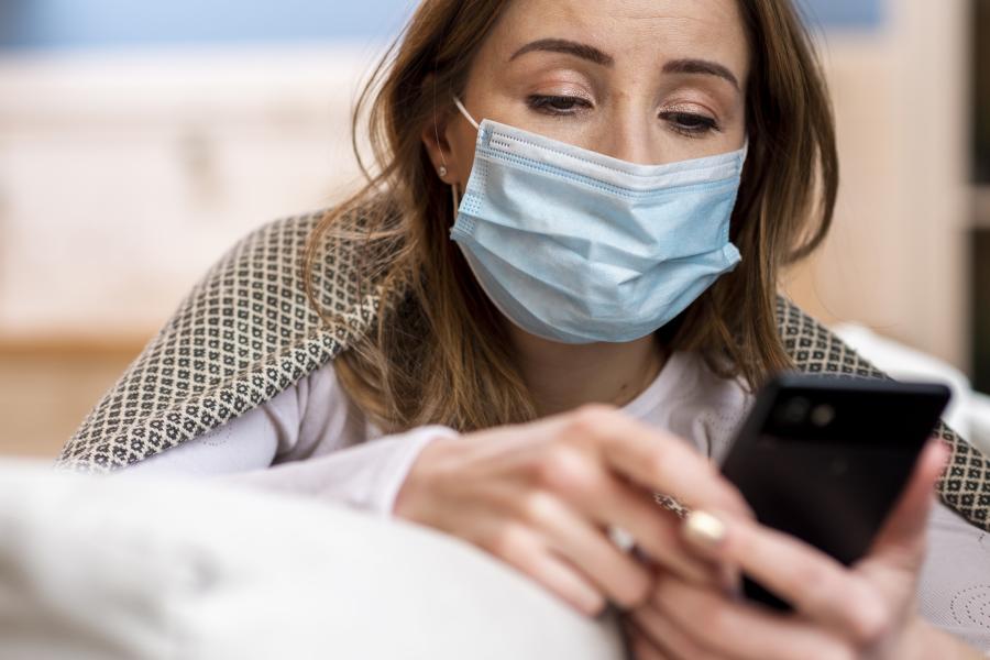 Patient with a face mask and their phone