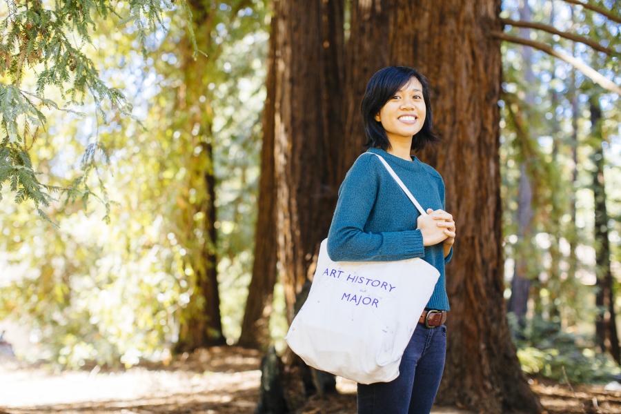 Student walking in the outdoors with trees
