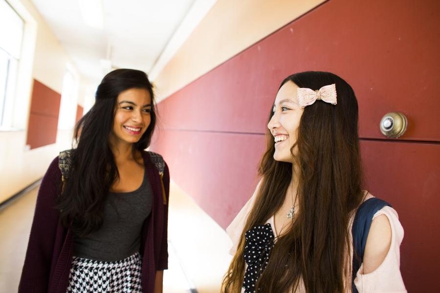 Students smiling and walking in hallway